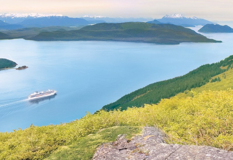 Coral Princess sailing Alaska's Inside Passage between forested islands and snowcapped peaks. Photo: Princess Cruises